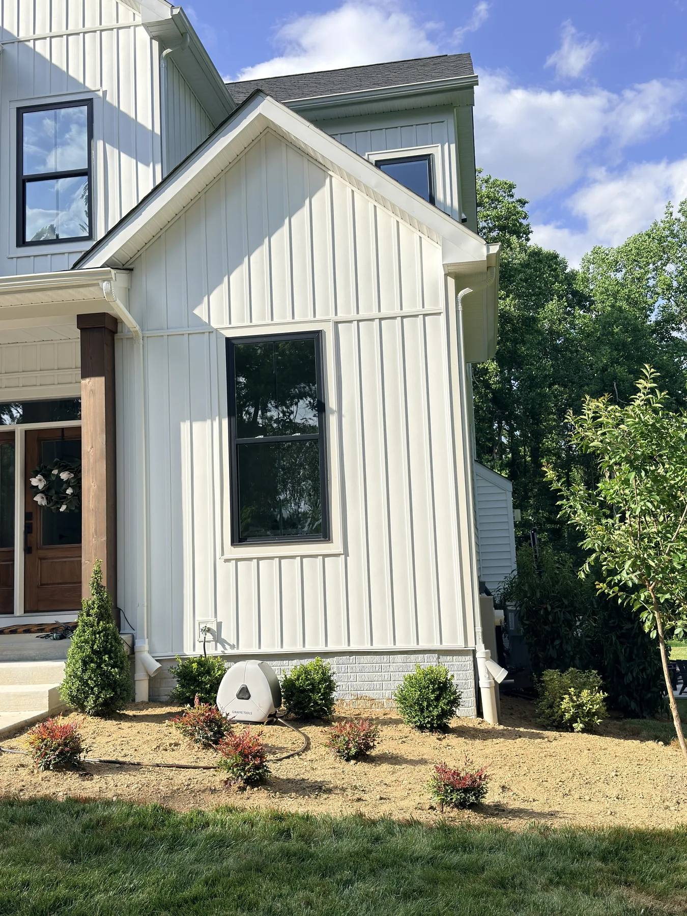 Boxwoods and colorful shrubs planted along the side of a Harford County home